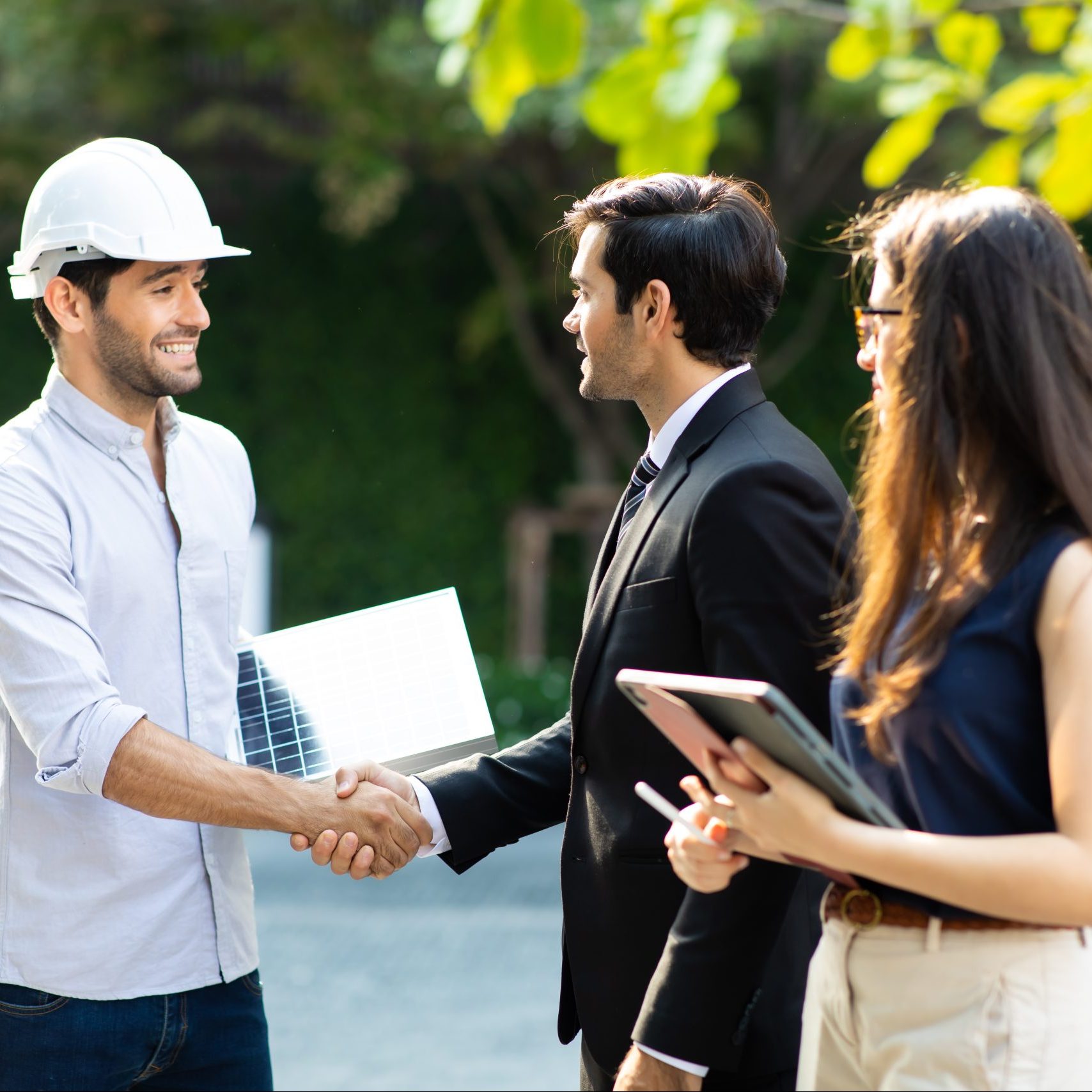 A solar power expert shaking hands with homeowners