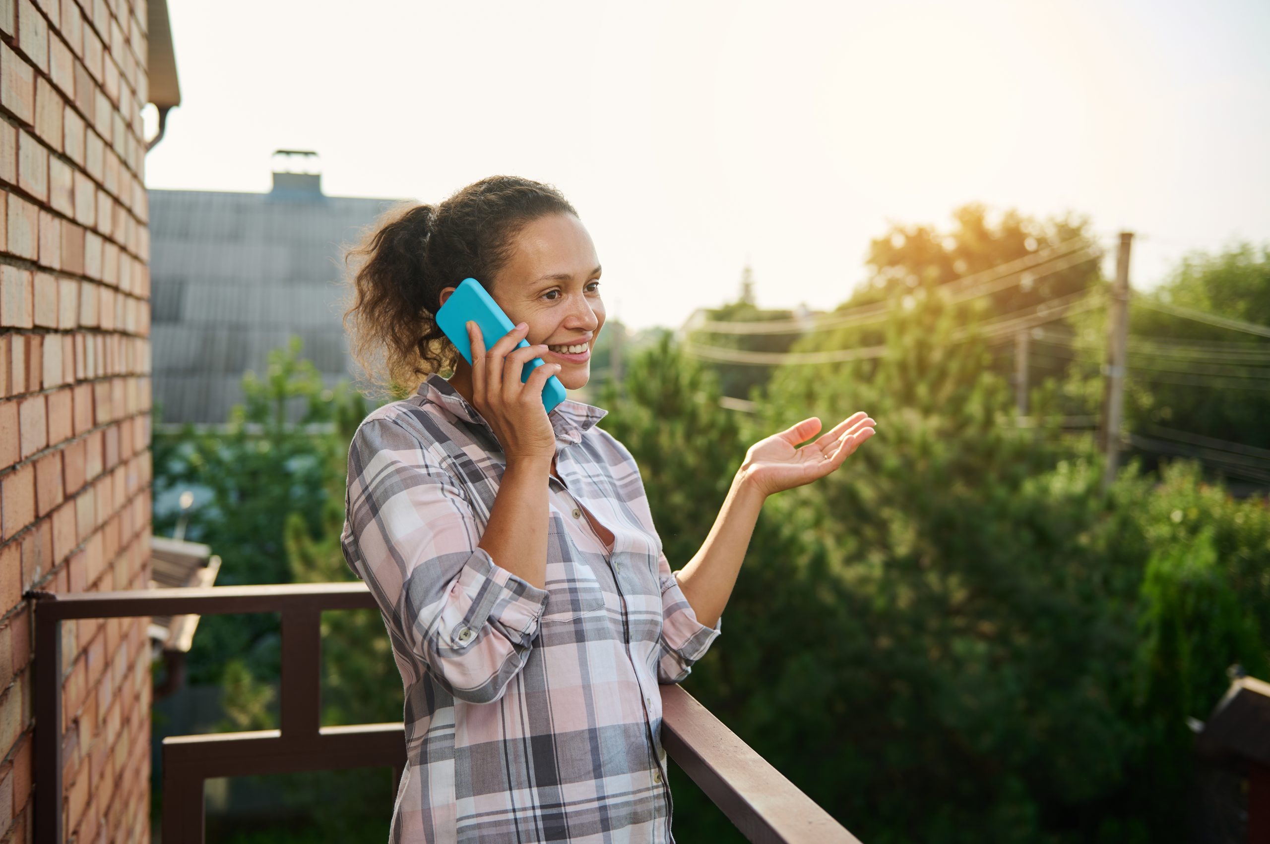 A smiling woman talking with a solar panel expert on the phone