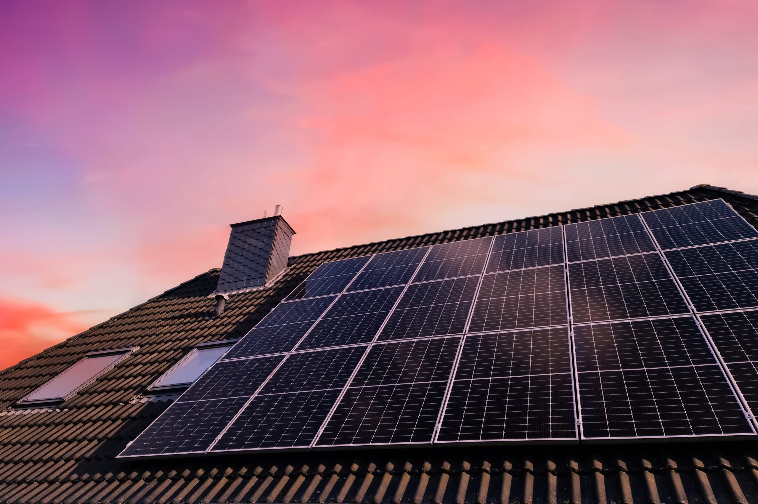 A solar panel system on a roof at sunset